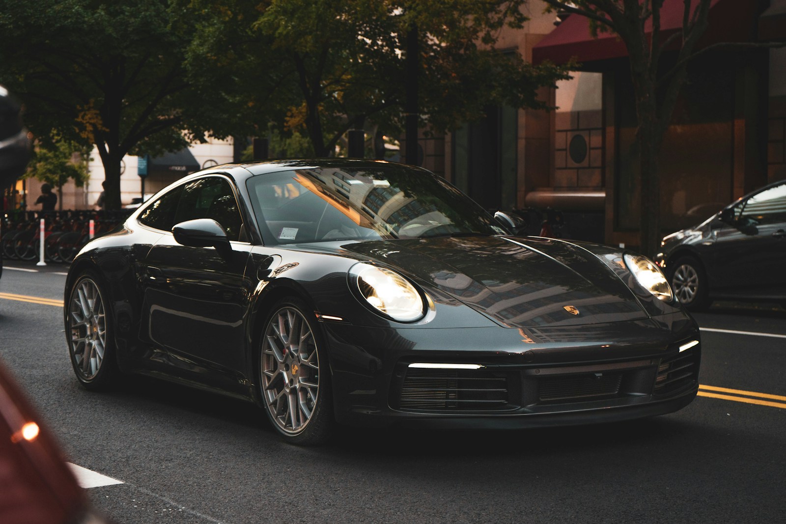 a black porsche parked on the side of the road